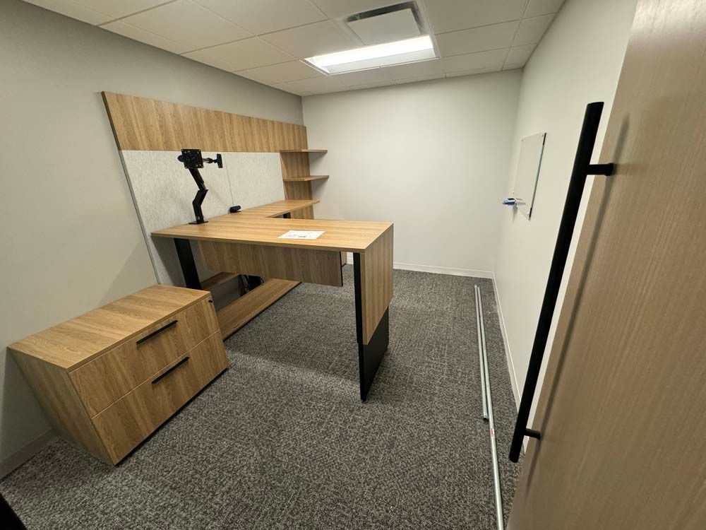 A small office with a wooden desk and cabinets.