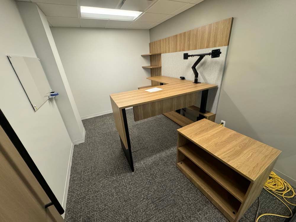 A small office with a wooden desk and shelves.