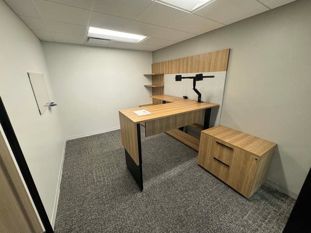A small office with a wooden desk and cabinets.