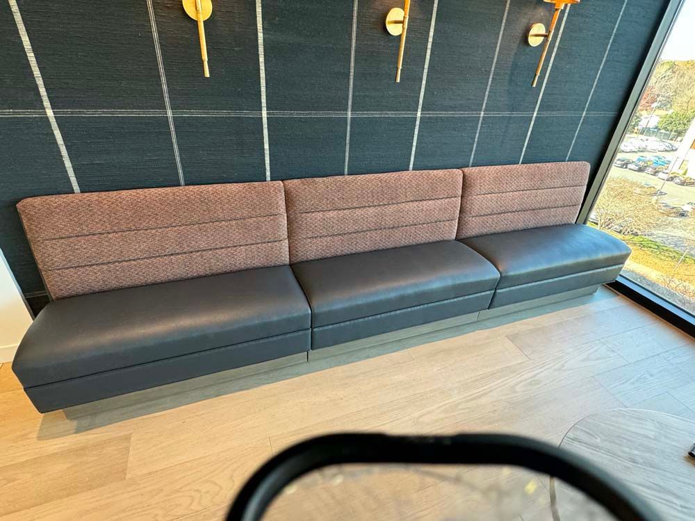 A couch is sitting in a room next to a window.
