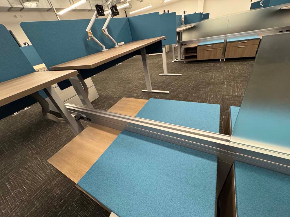 A reflection of a desk in a mirror in an office cubicle.