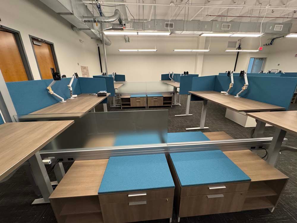 A room with a lot of desks and blue dividers