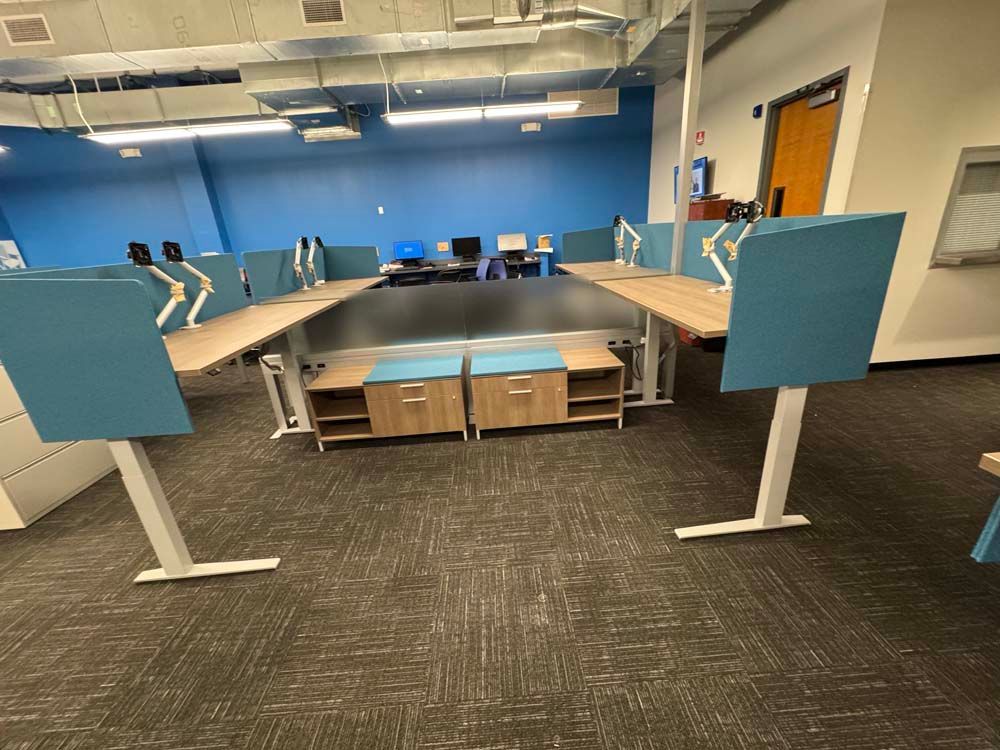 A room with a lot of desks and a blue wall