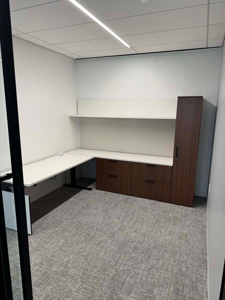 A room with a desk and cabinets in it.
