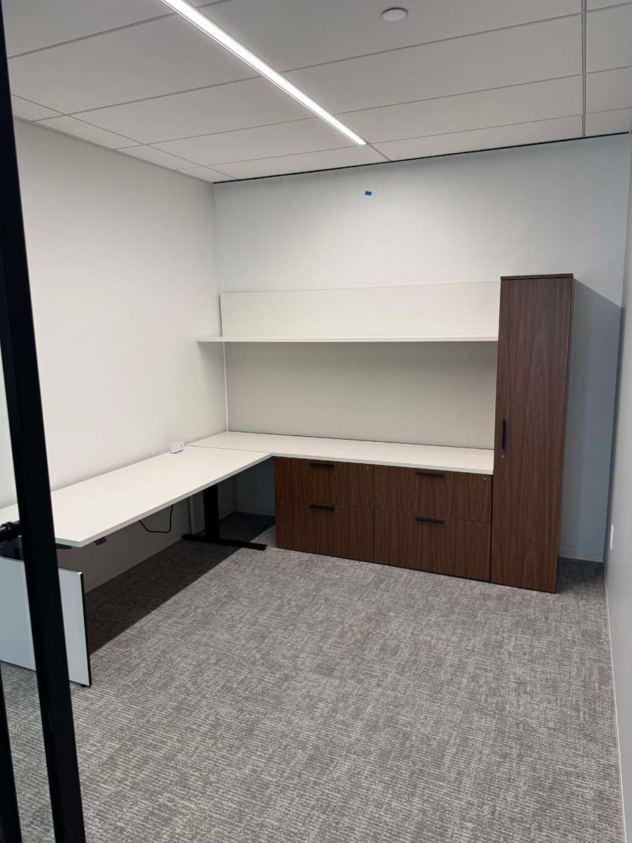 A room with a desk and cabinets in it.