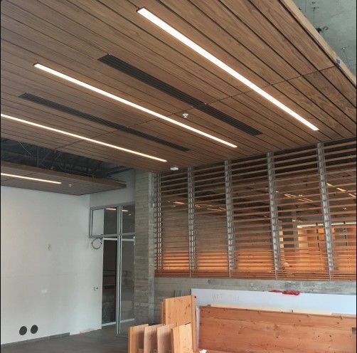 Wooden ceiling with recessed lights, louvred window, open doorway, and unfinished interior.