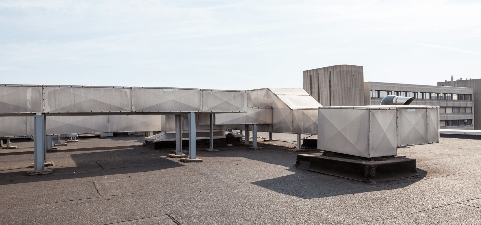Modified bitumen commercial flat roof with HVAC exhaust and ducting.