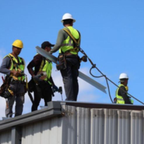 a group of construction workers standing on top of a building
