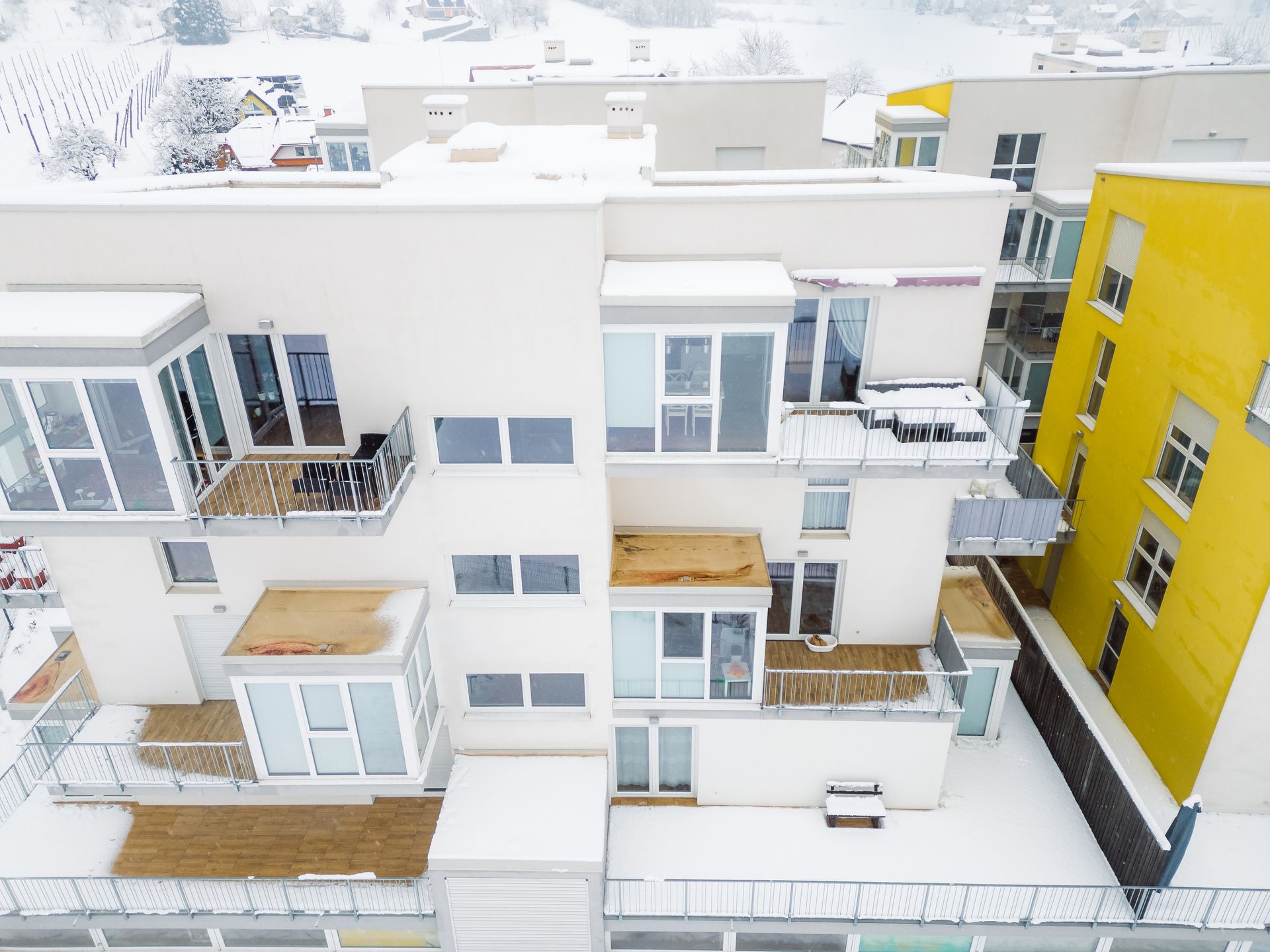 An aerial view of a large apartment building covered in snow.