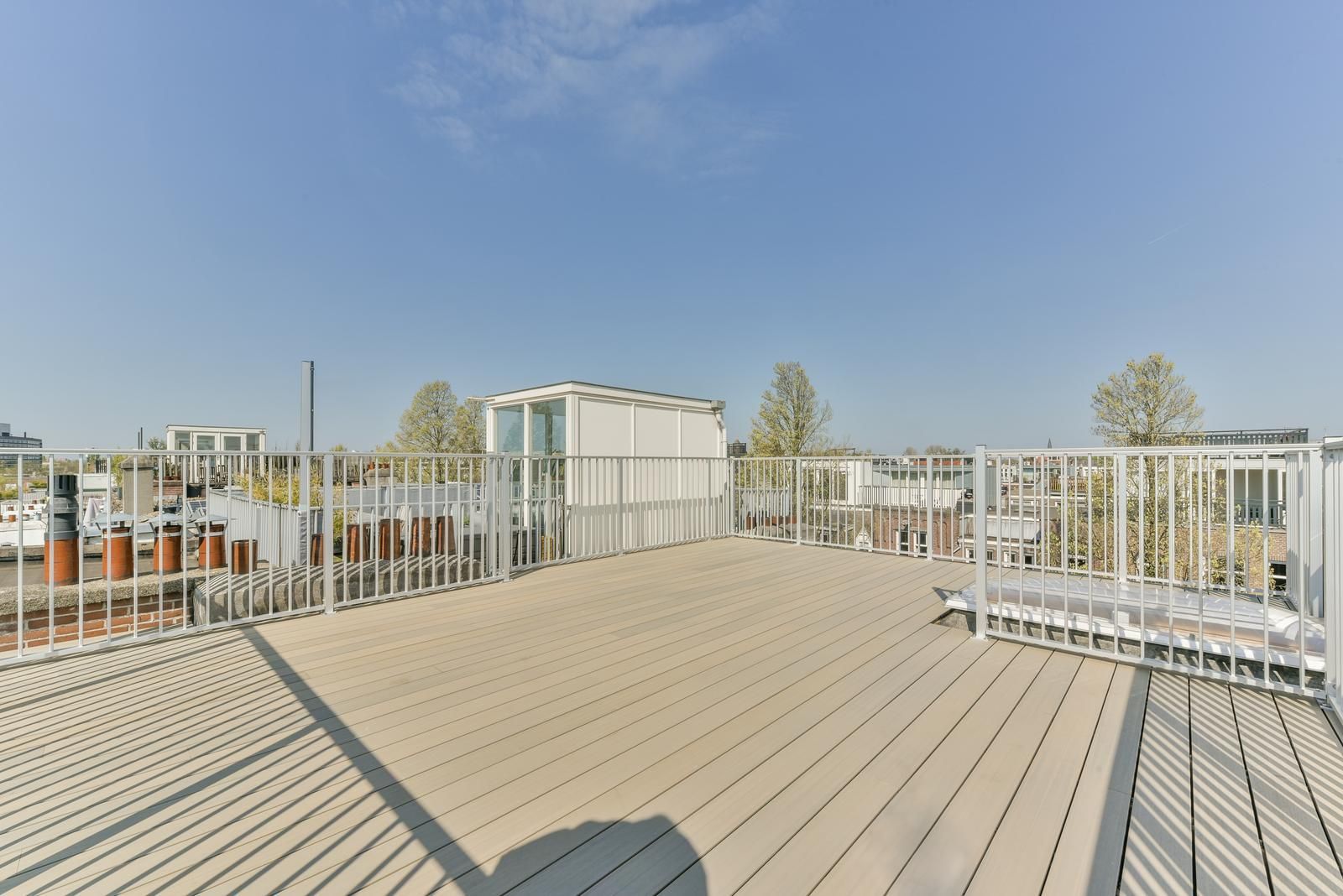 A flat roof with a metal railing in the summer