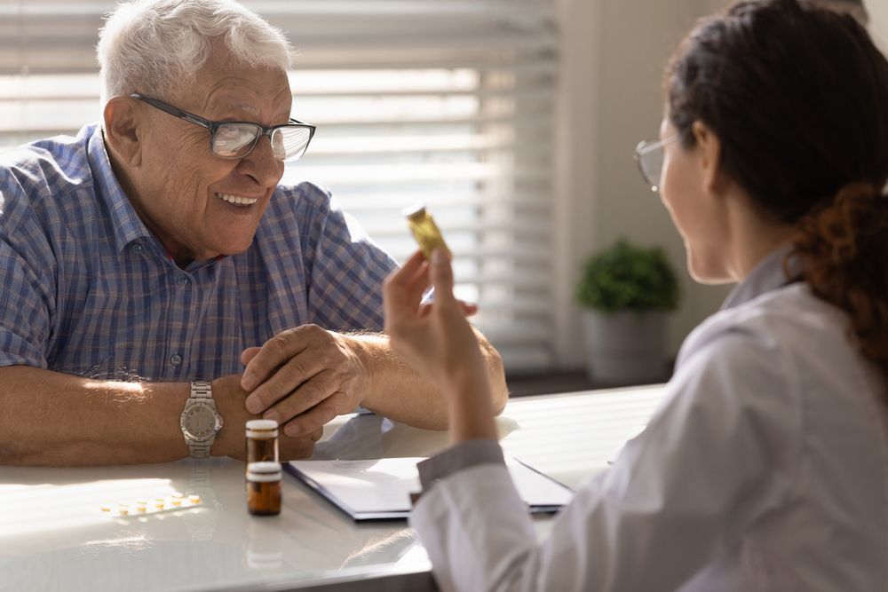 Doctor showing medication to a patient in an office setting.
