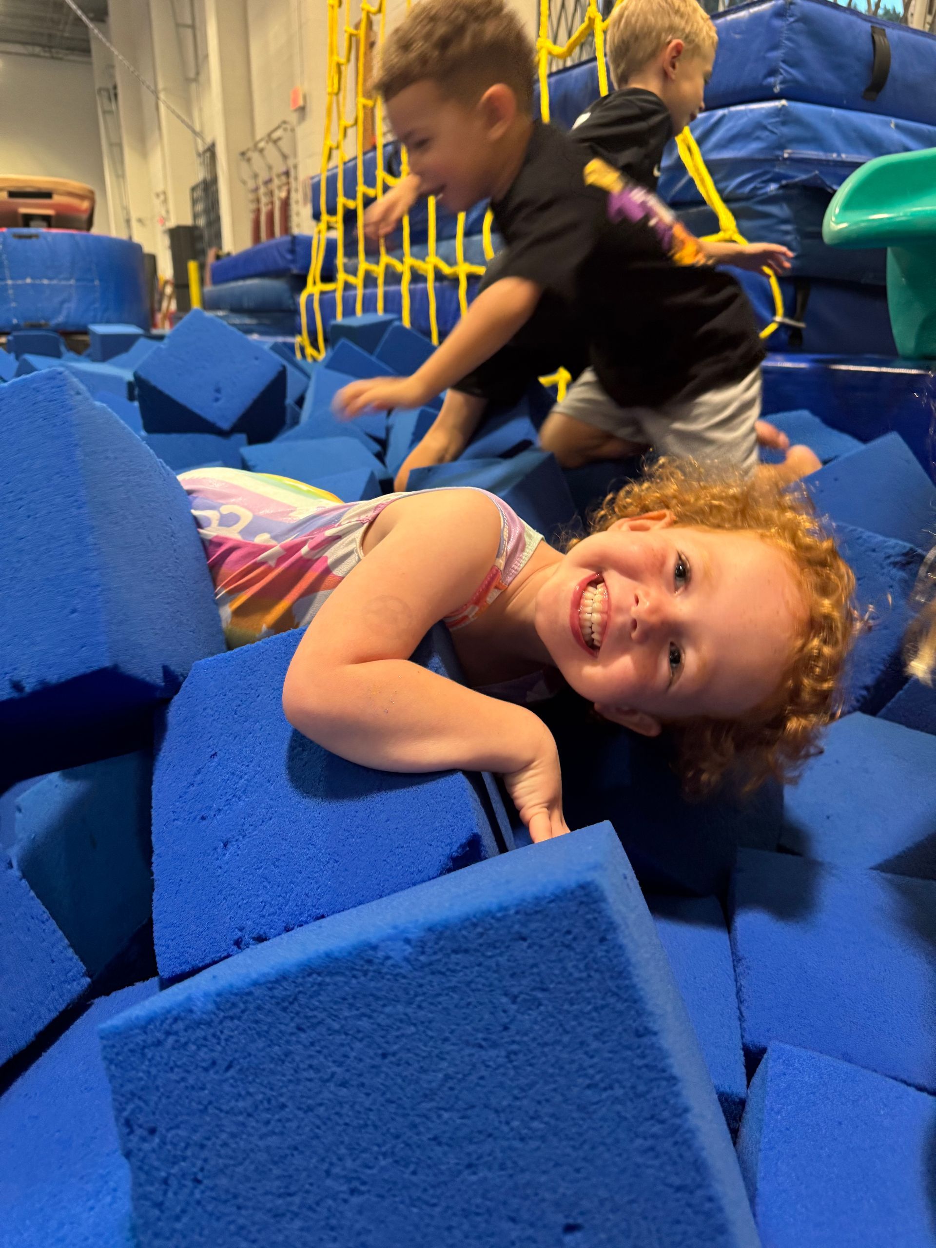 A group of children are sitting at a table with a birthday cake.