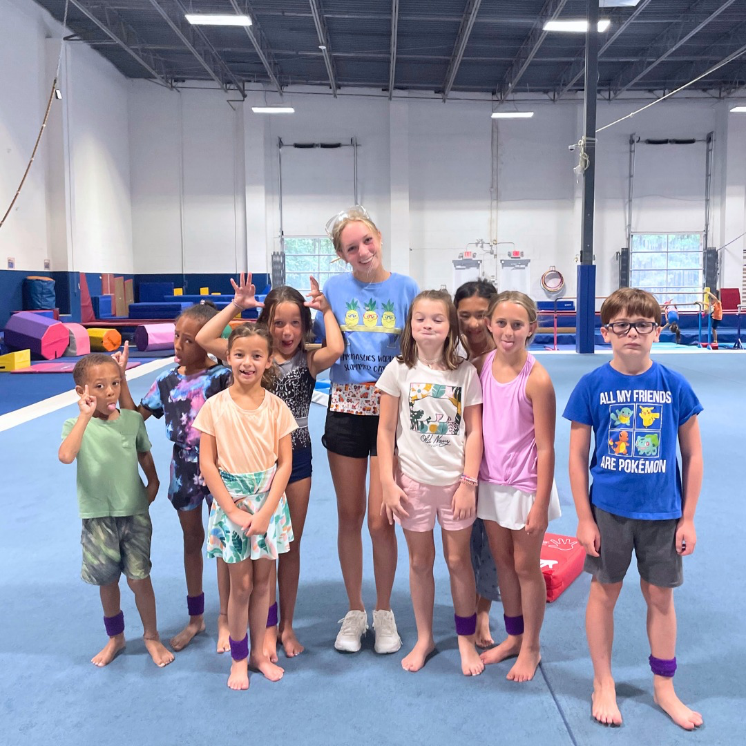 A group of children are posing for a picture in a gym.