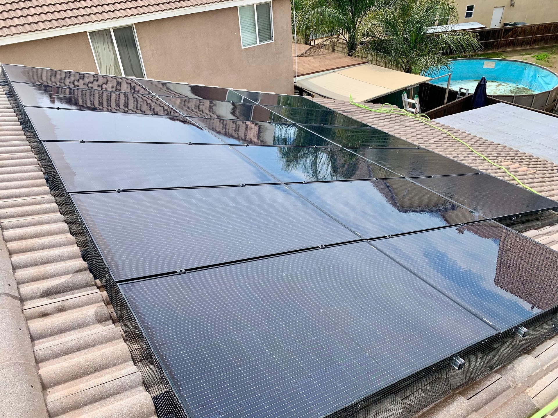 There are many solar panels on the roof of a house.