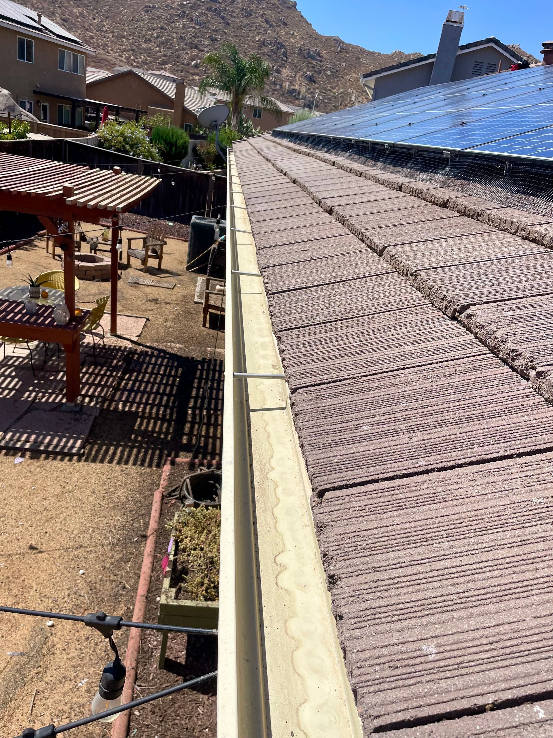 A close up of a gutter on the side of a roof.