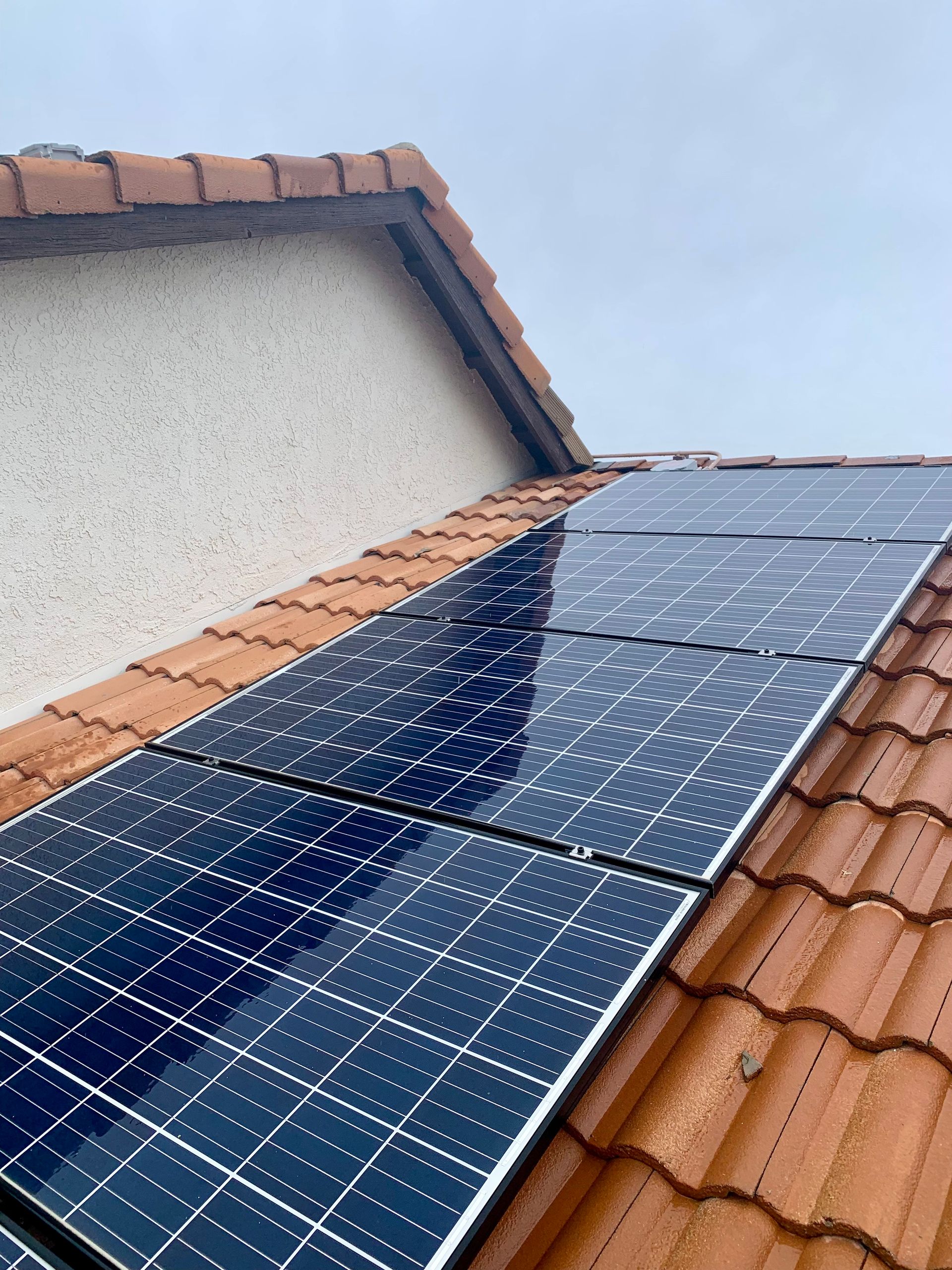 A row of solar panels on a tiled roof