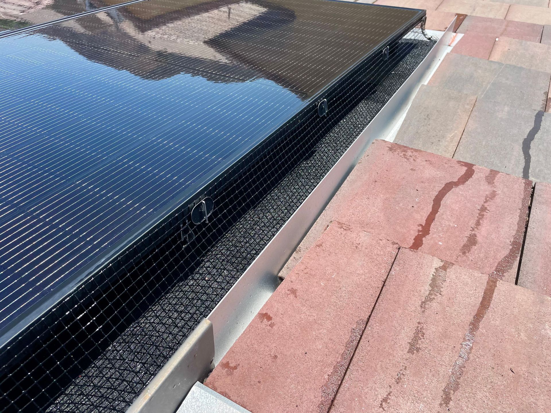 A solar panel is sitting on top of a brick walkway