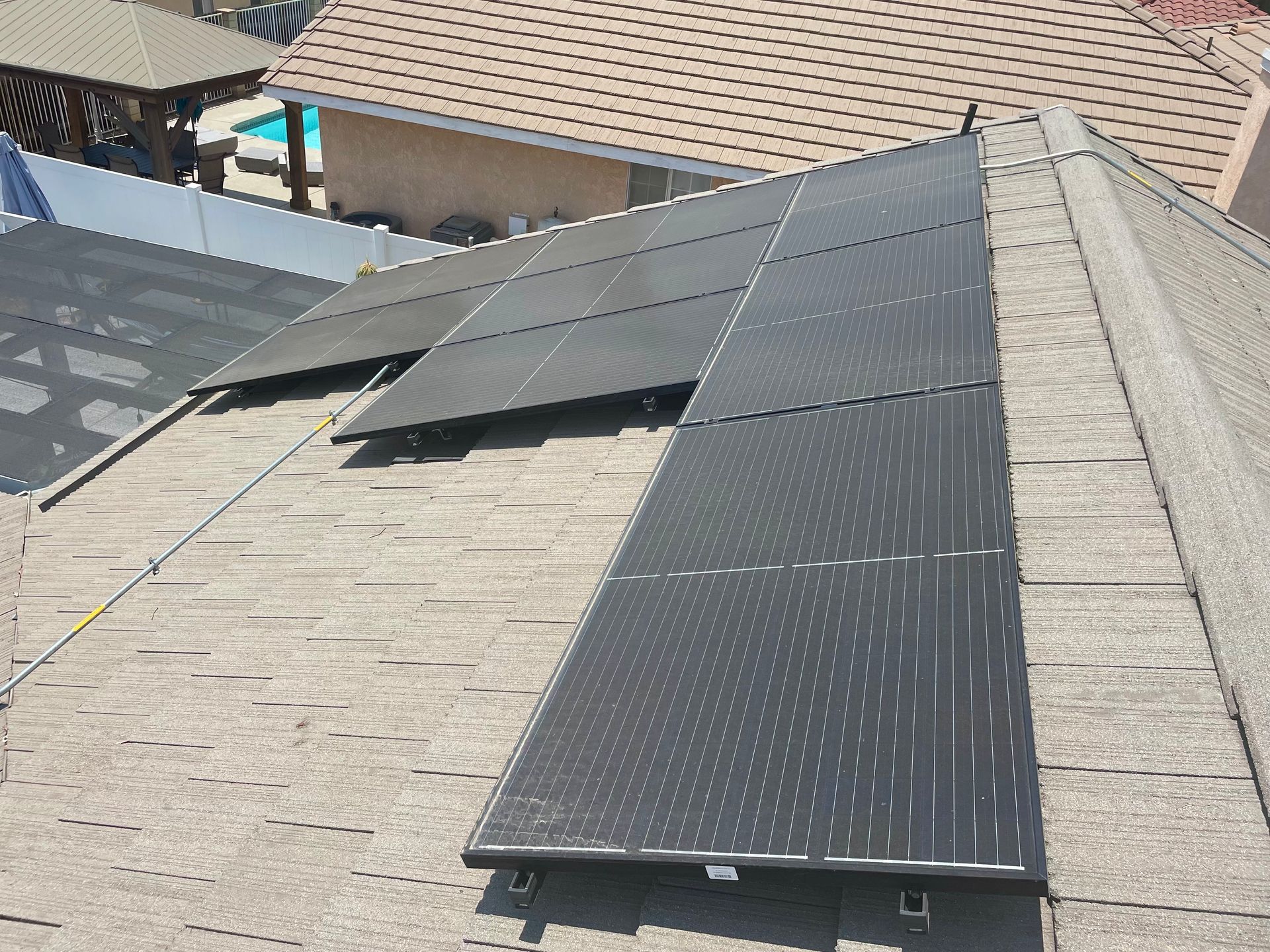 A row of solar panels are sitting on top of a roof.