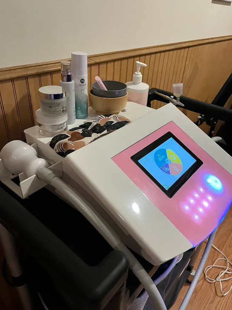 Beauty machine with pink accents, skincare products, and a small screen displaying a pie chart.
