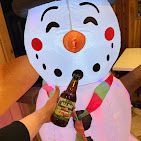 Inflatable snowman drinking a beer, holding a bottle.