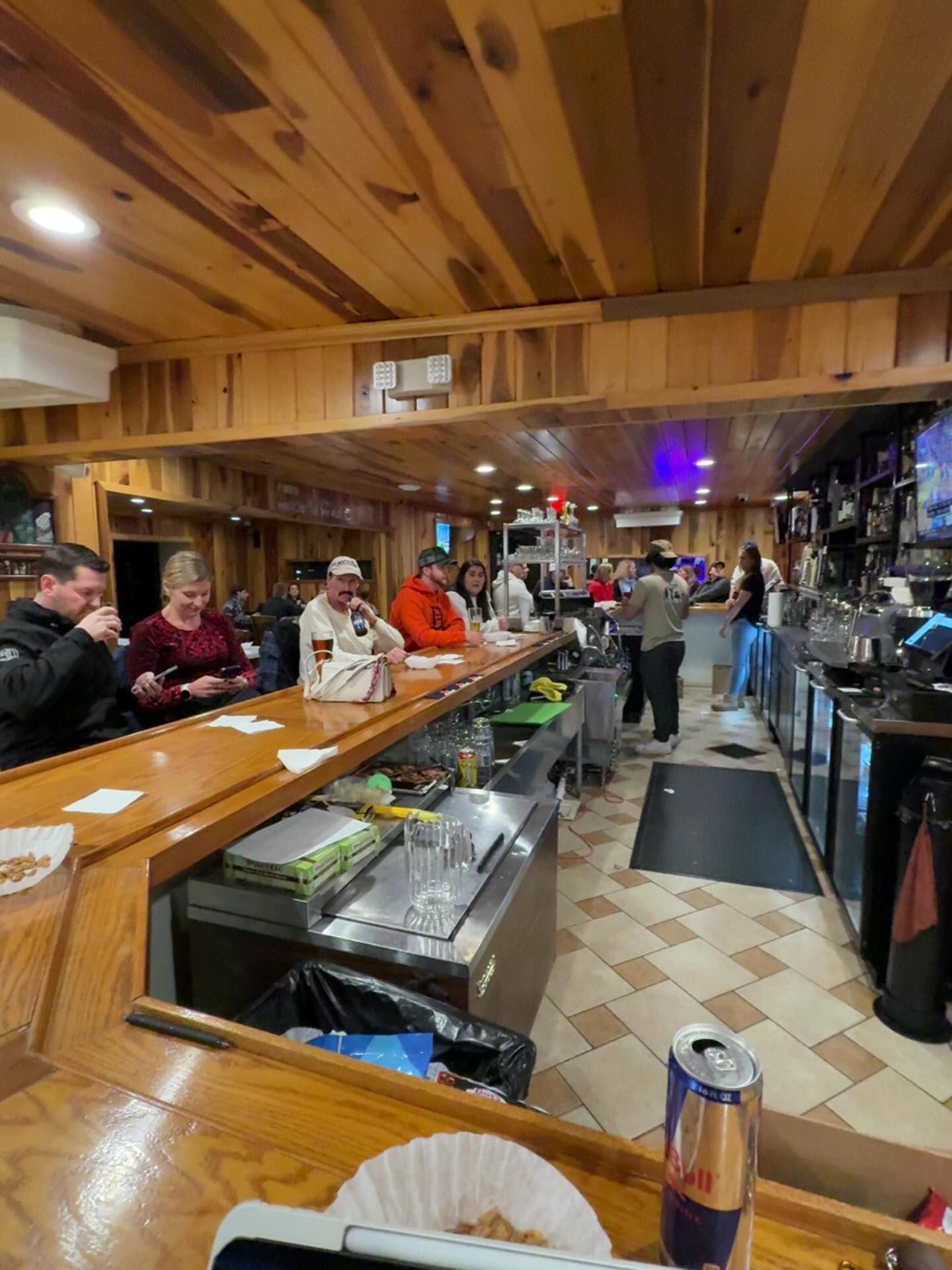 Five women singing on stage with microphones, lit by blue and red stage lights.