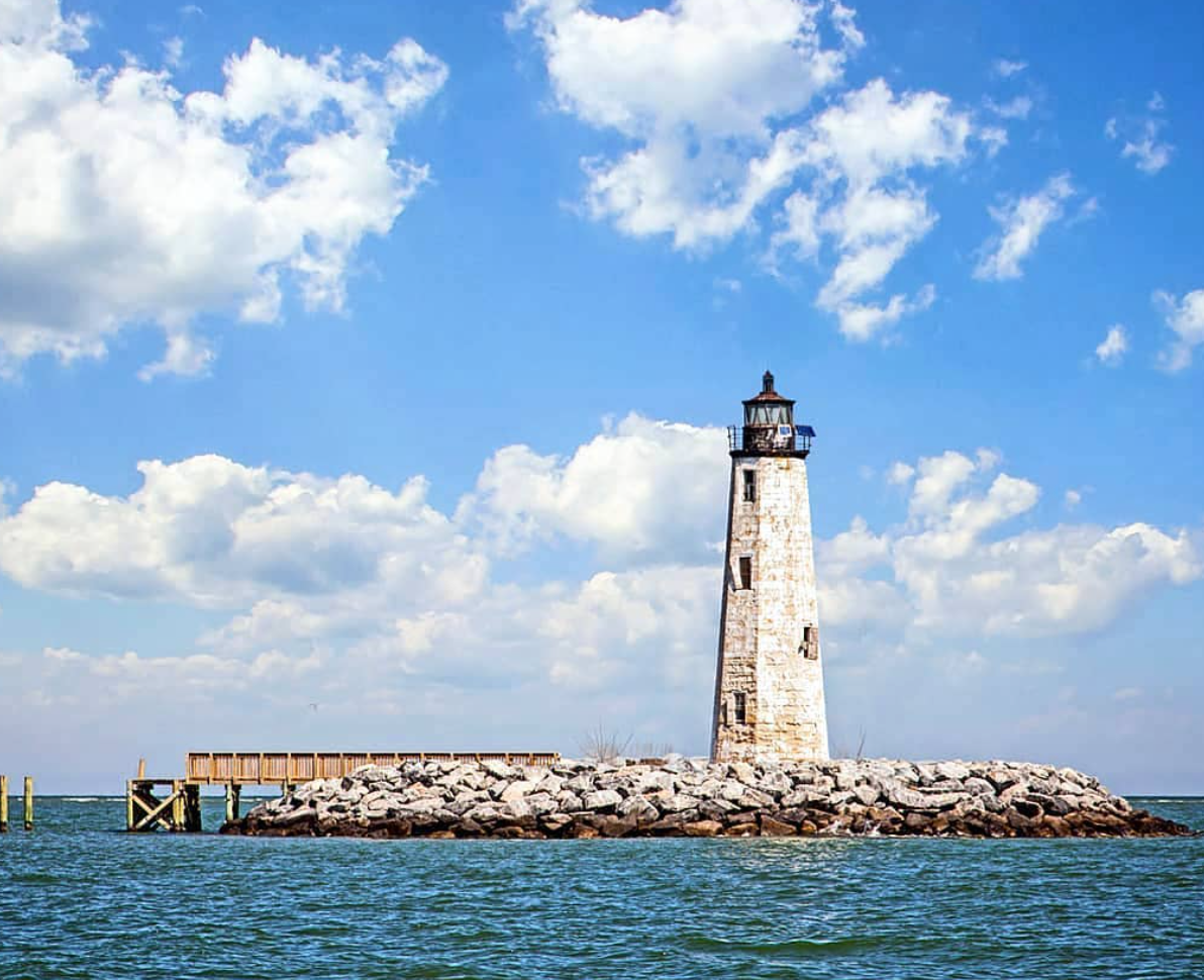 Modern two-story house with glass walls, wooden accents, and a rooftop pergola.