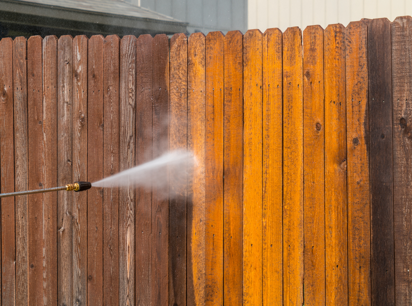 Pressure cleaning a dirty wood fence in Houston, Texas