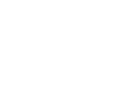 A brightly lit school classroom with rows of desks, colorful educational posters on the walls, and a large chalkboard.