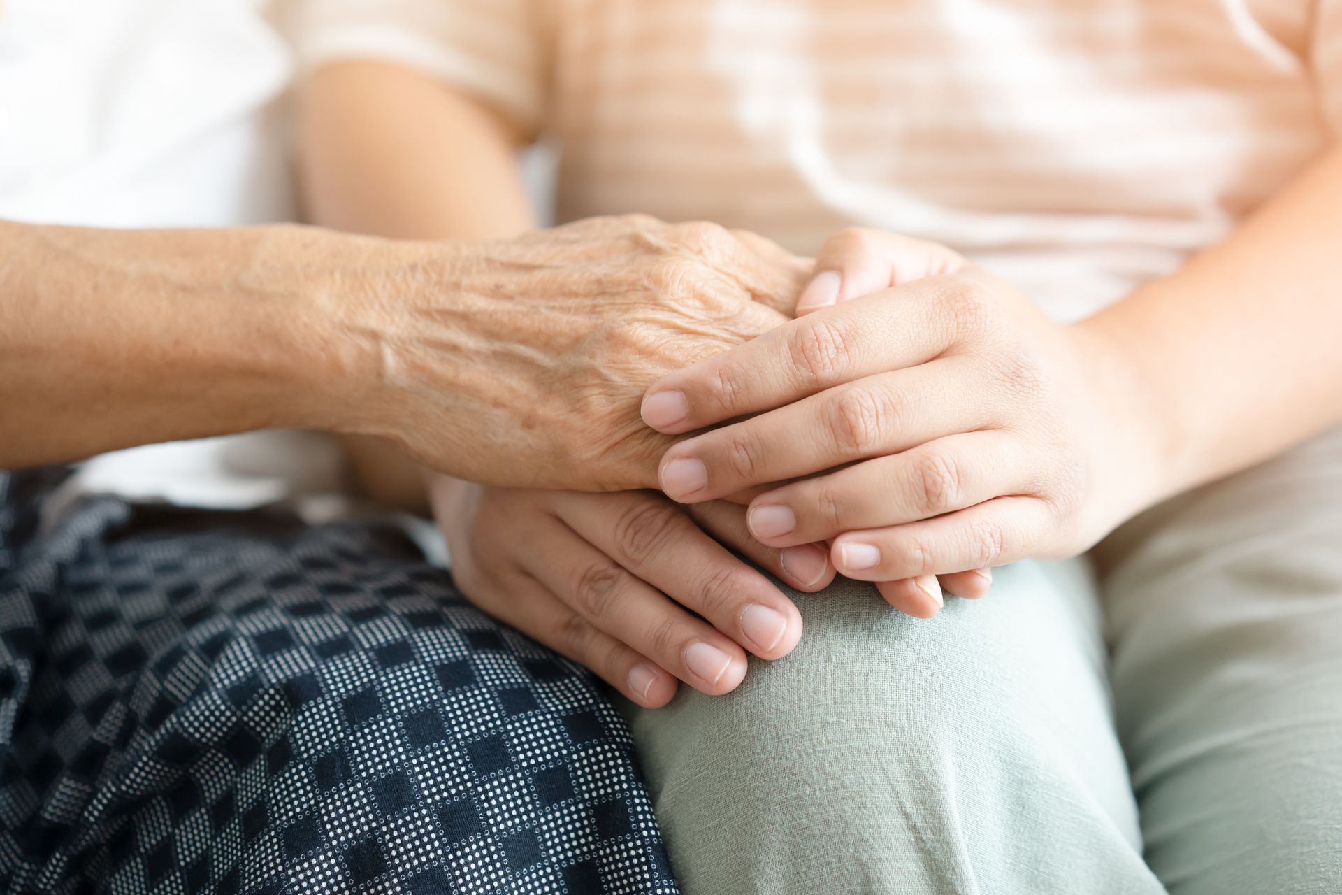 Two hands holding each other gently, showing comfort and support.