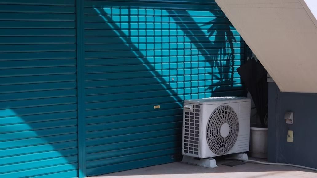 An HVAC system in front of a blue wall