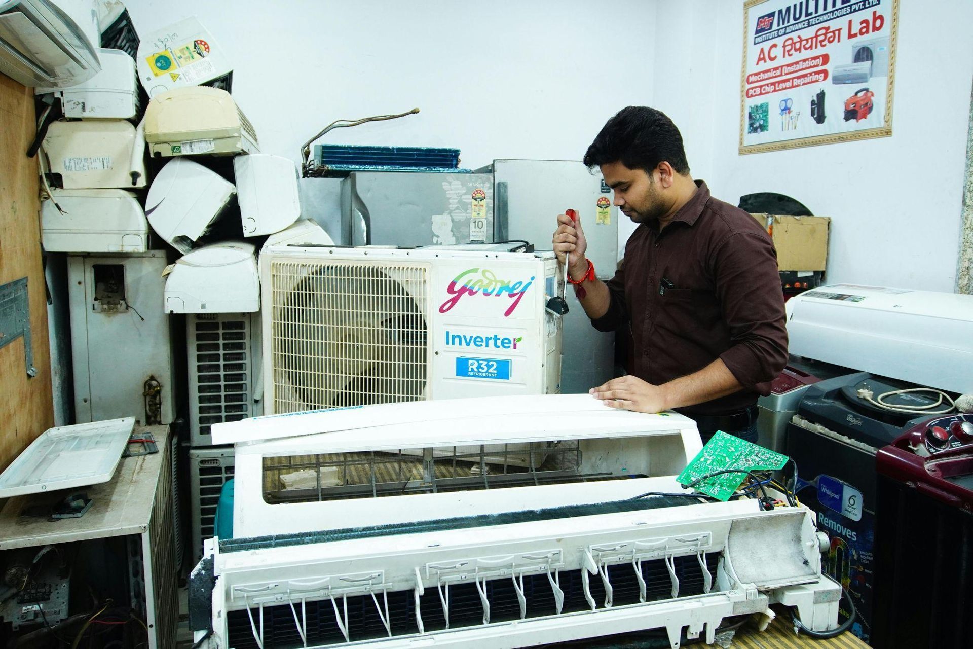 This photo shows a technician fixing an AC unit. 