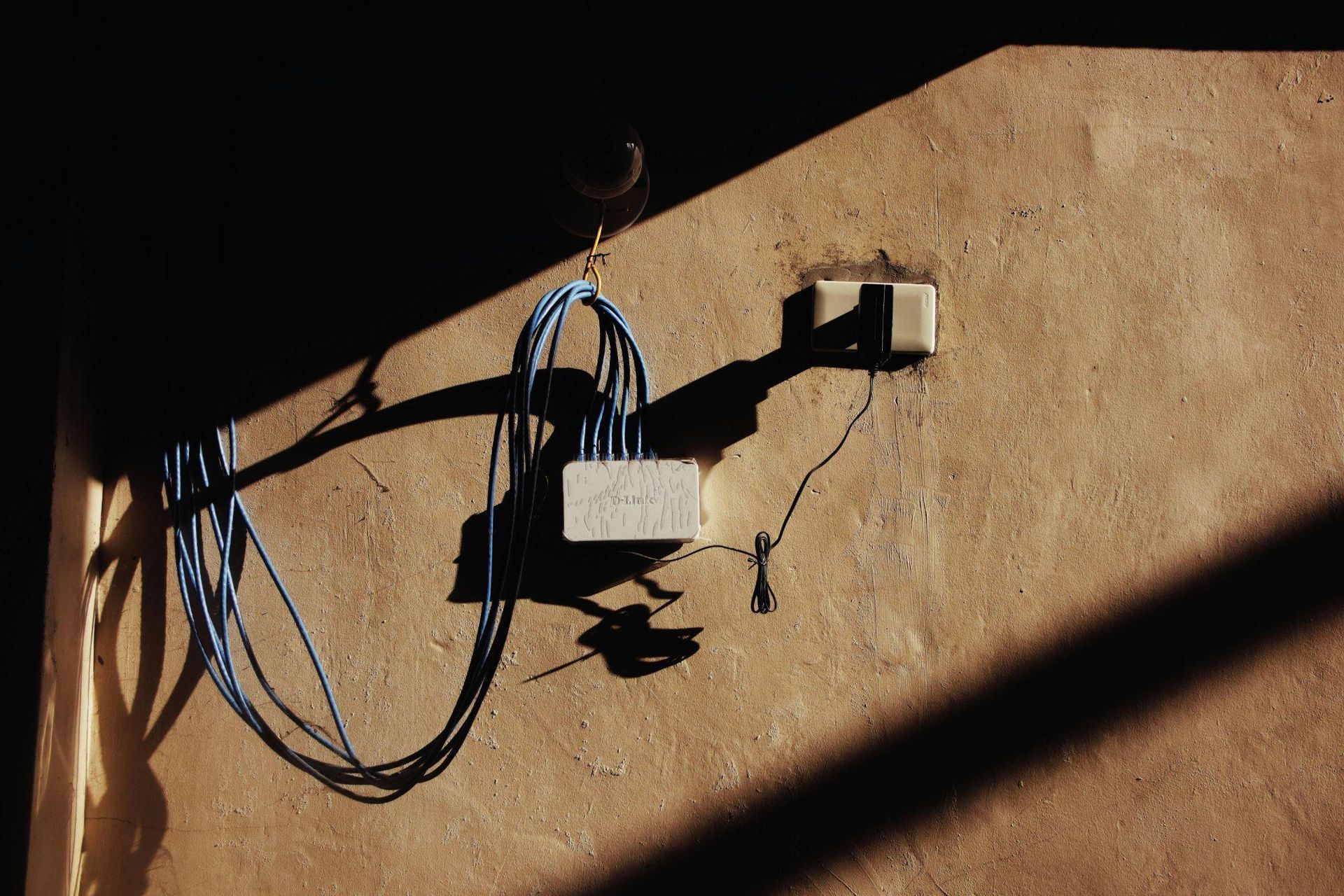 This photo shows a switch on a wall with wires plugged into it.