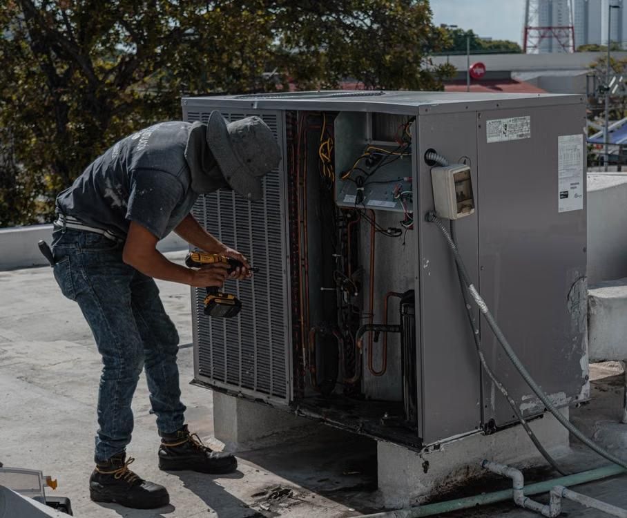 a man fixing an AC unit.
