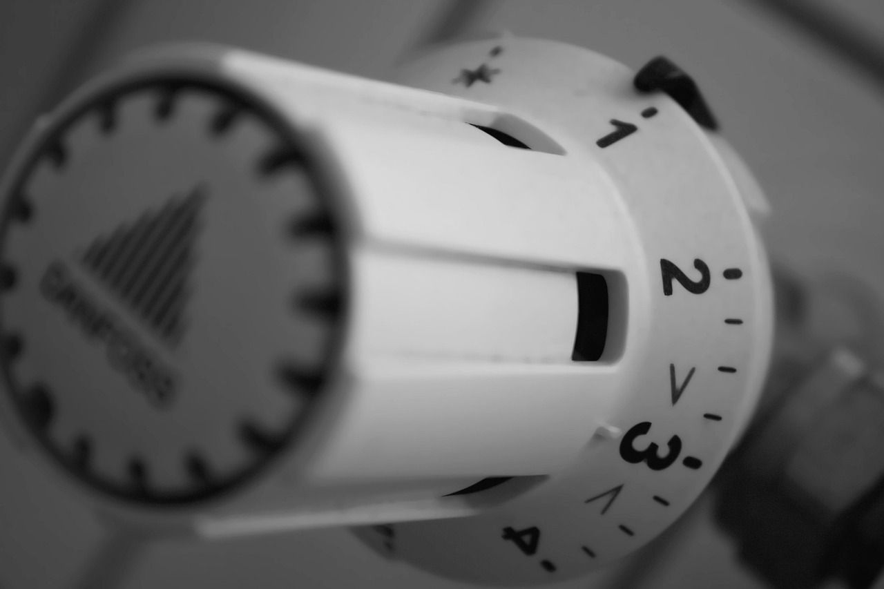 Close-up of a thermostat dial, representing uneven heating and temperature control issues that signal furnace replacement signs.