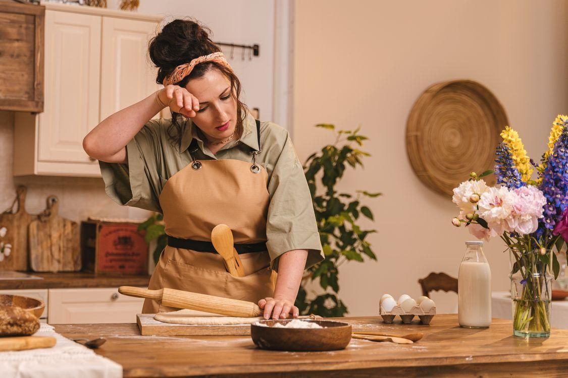 A woman cooks in her kitchen. 