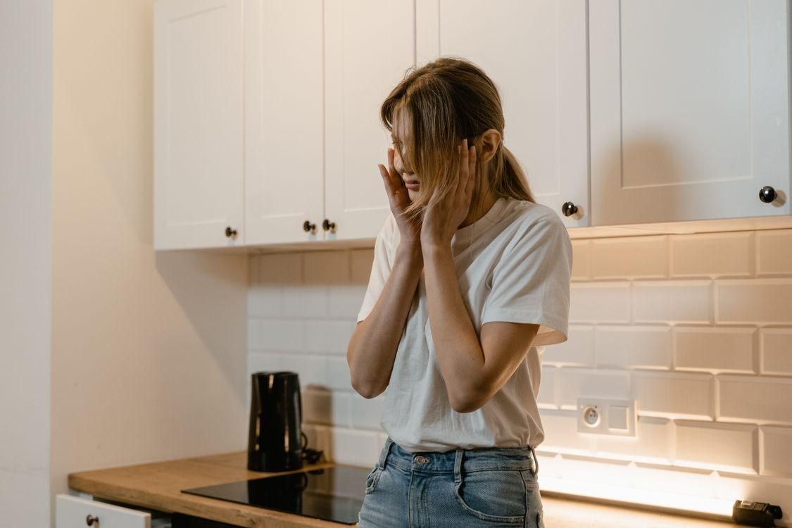 A woman feeling hot in the kitchen