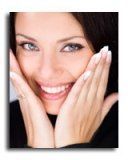 Woman with hands near face, smiling widely, showing teeth, with light nail polish.