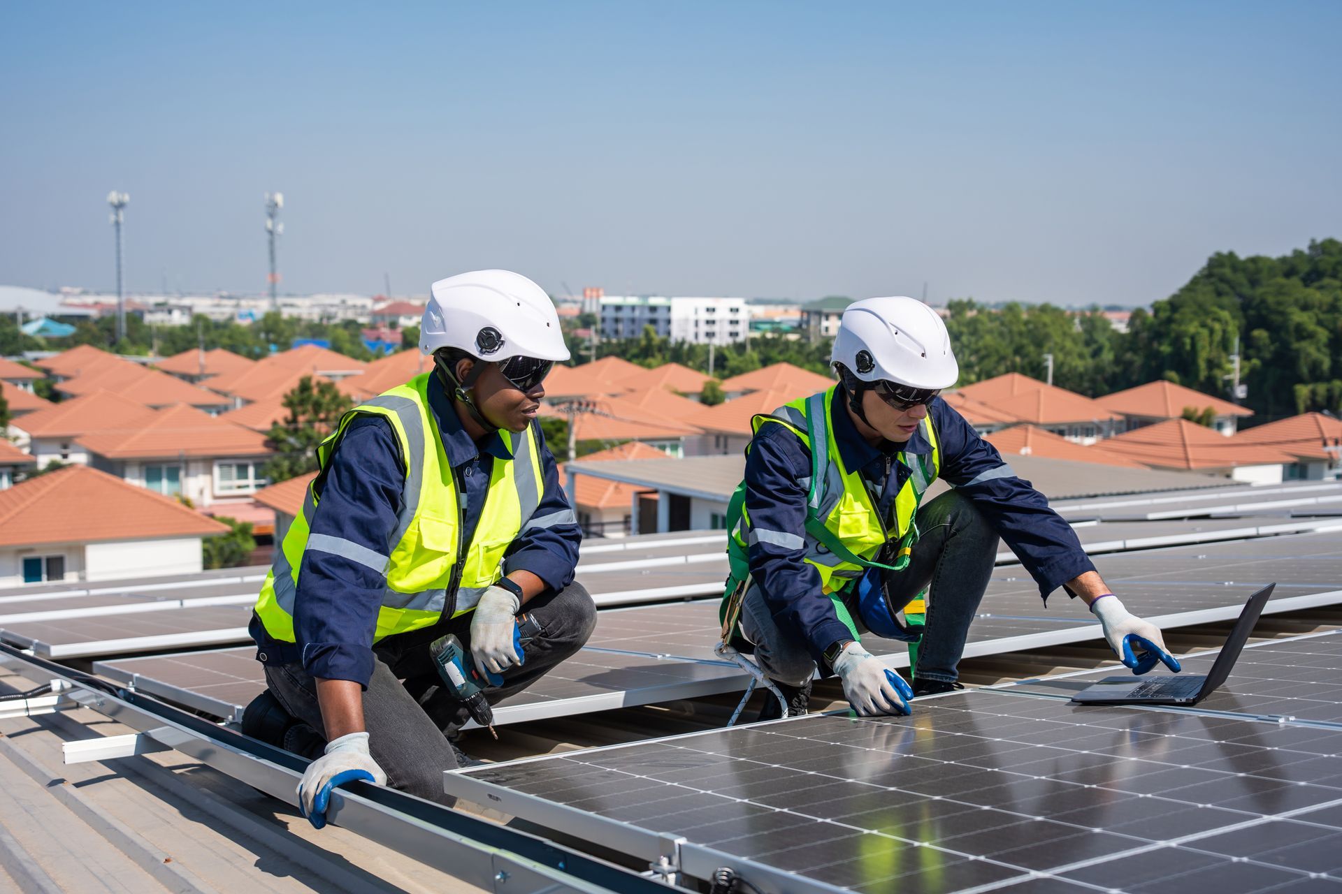 Two men are installing solar panels on the roof of a building.