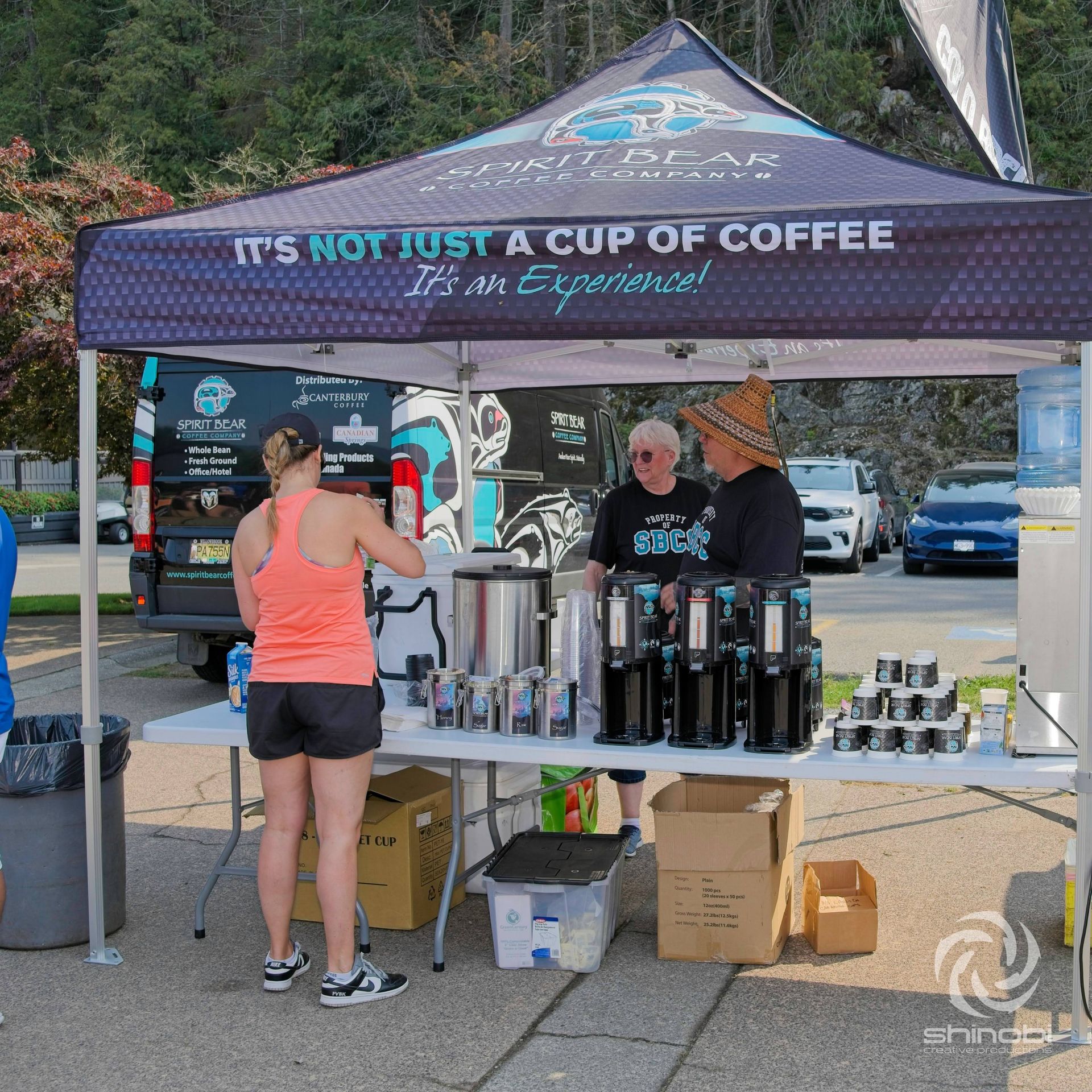 People standing under a tent that says it 's not just a cup of coffee