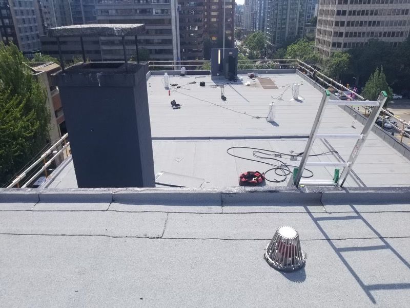 A rooftop with a chimney and a ladder on it