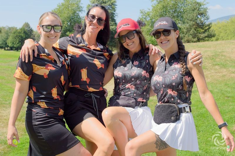 A group of women are posing for a picture on a golf course.