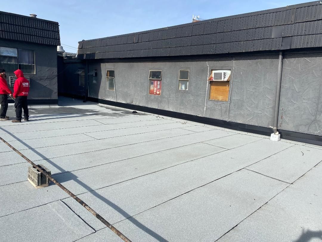 A group of people are standing on the roof of a building.