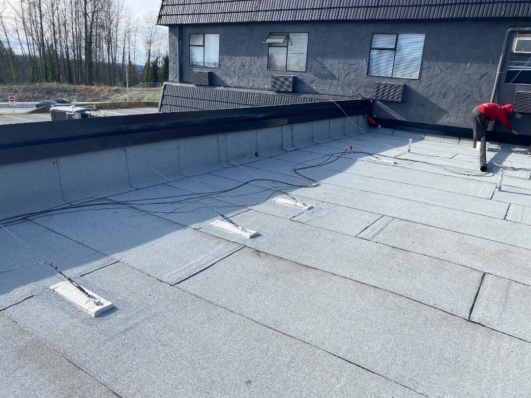 A man is working on the roof of a building.