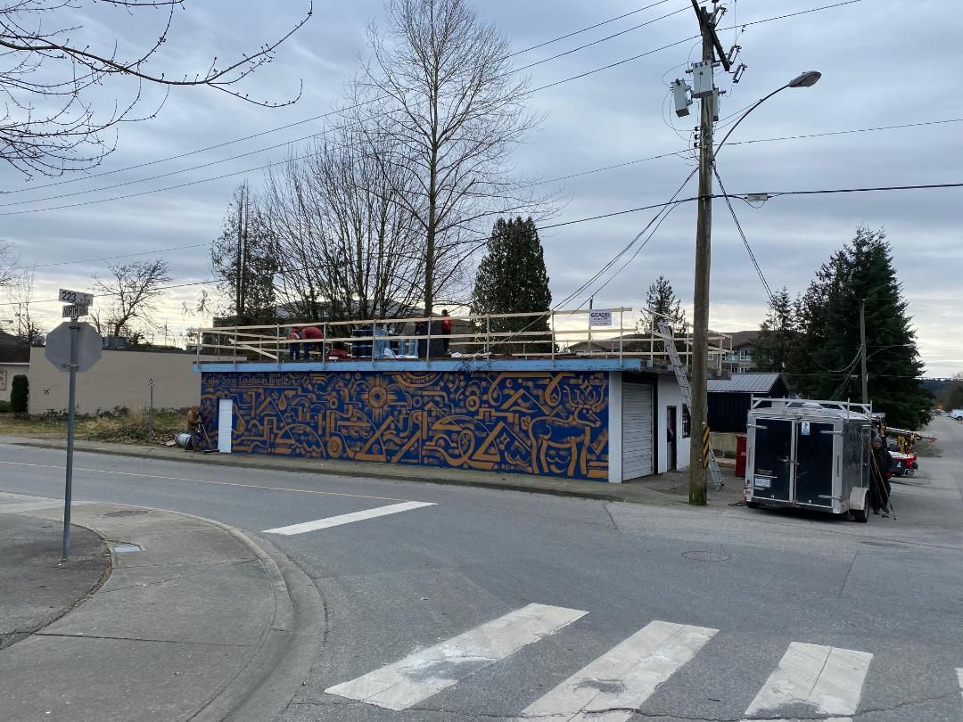 A building with graffiti on it is sitting on the corner of a street.