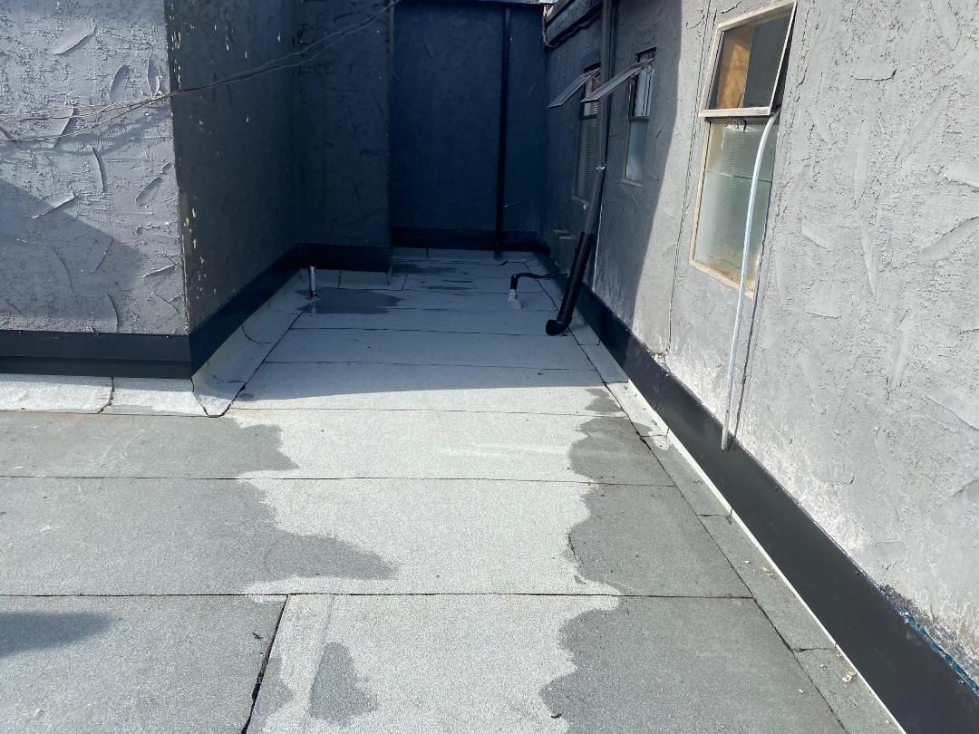 A concrete walkway leading to a building with a window.