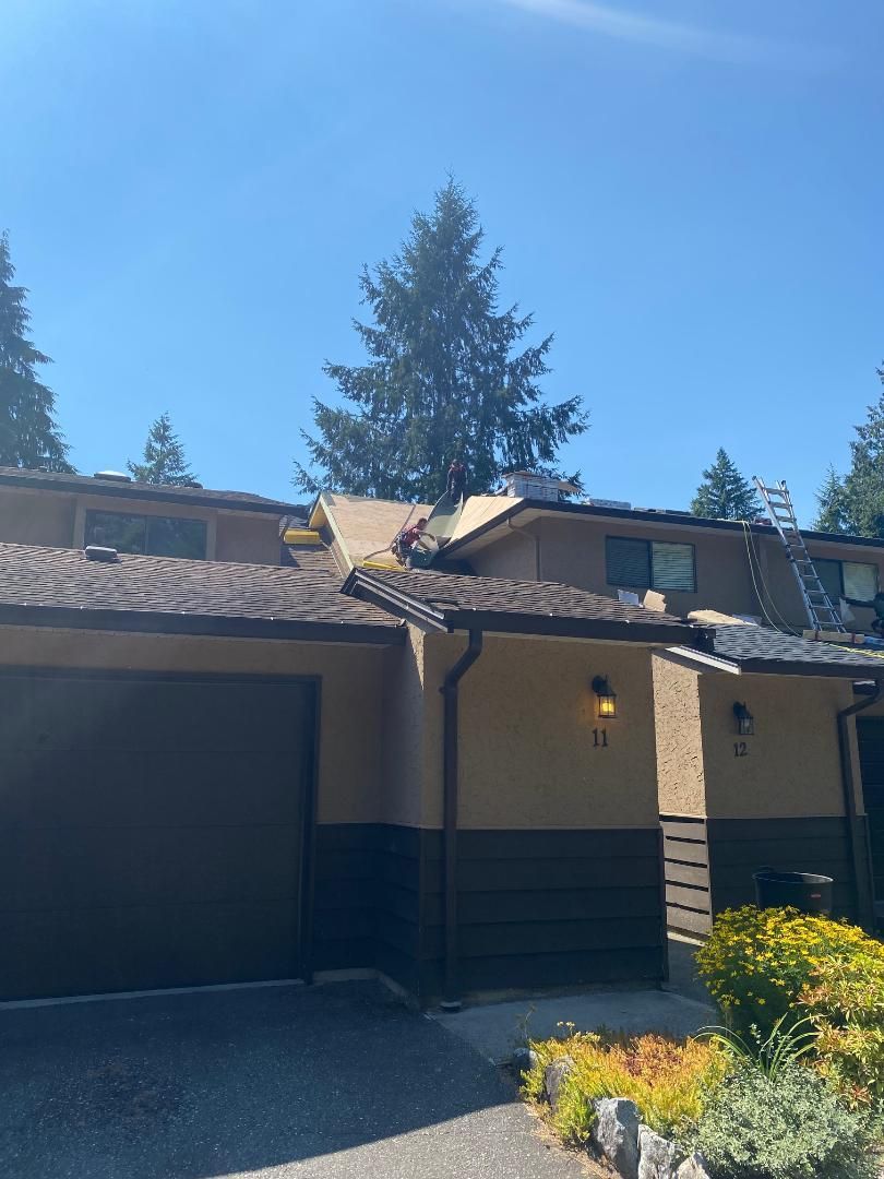 A roofer is working on the roof of a house.