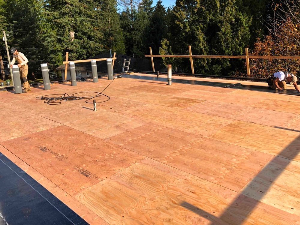 A group of men are working on a wooden roof.