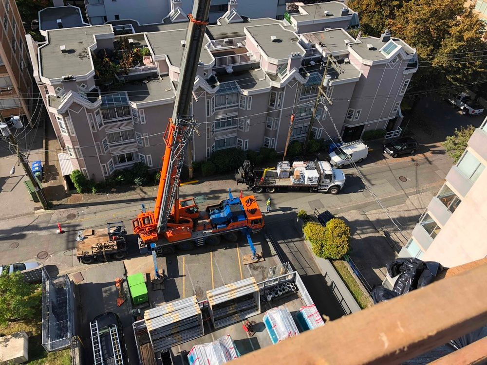 An aerial view of a construction site with a crane and trucks.