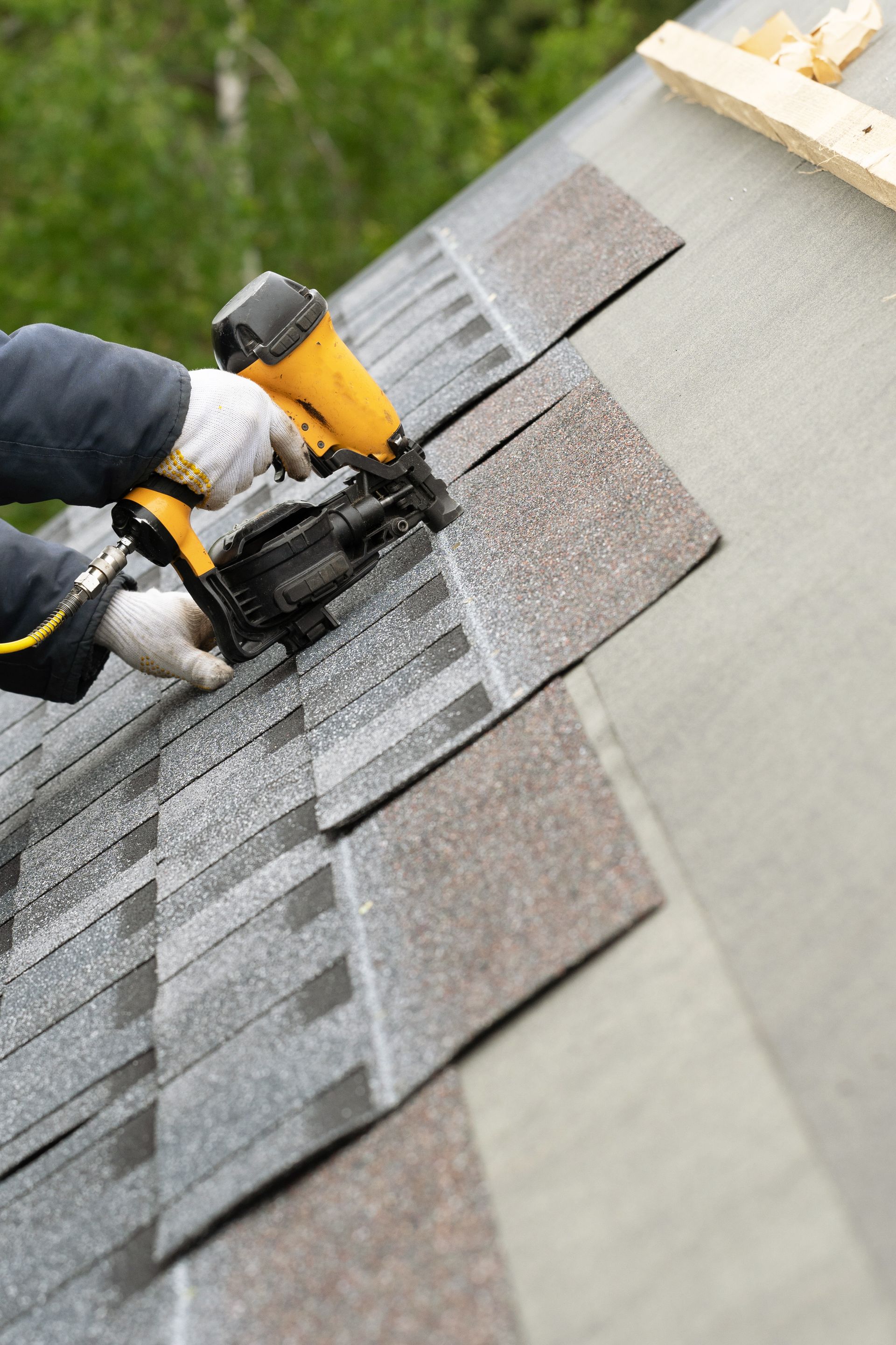 A person is installing shingles on a roof.