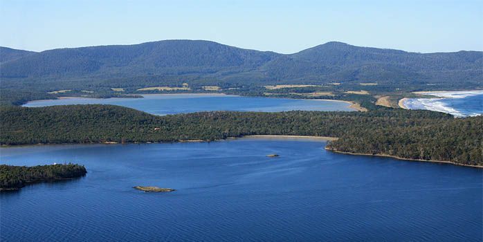 An aerial view of a lake surrounded by mountains and trees.